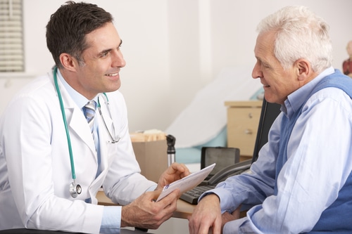 Médico hablando con un hombre mayor en una consulta sobre testosterona baja crónica